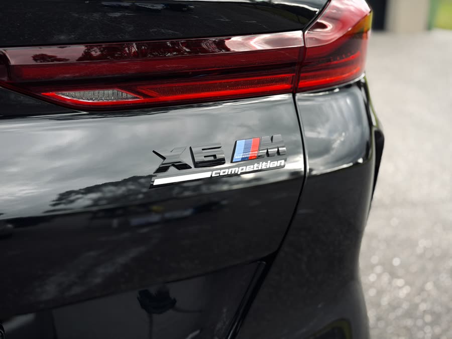 Glossy black BMW X6 M rear badge and tail light after a Signature Full Detail